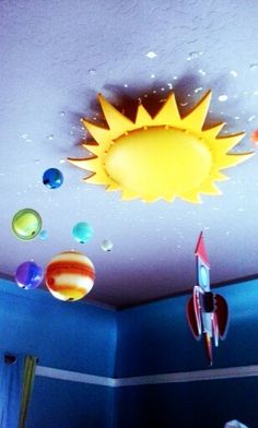 the sun is shining brightly in this children's room with planets on the ceiling