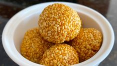 four balls of sesame seeds in a white bowl