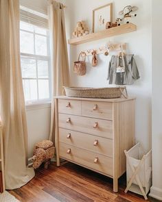 a baby's room with a dresser, teddy bear and other items on the wall