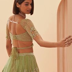 Muted jade green lehenga embellished with pearl and glass floral motifs teamed with a modern blouse with geometric embroidery and and strappy tie back. Includes an organza dupatta. Composition: Organza Care: Dry Clean Only and Vacuum Storage This product can be customised for sleeves, length of blouse and neckline Delivery : 4-6 weeks as the product is hand crafted. For more information and sizes please contact fabiliciousfashion@gmail.com or visit our Copenhagen studio.About the Designer : Parul Gandhi is a name that exudes opulence and elegance. The design philosophy of Parul Gandhi Label revolves around color balance and placement embroidery, resulting in styles that are both luxurious and understated. Whether it's modern wedding dresses or modern bridal gowns, Parul Gandhi has somethin Long Kurti Patterns, Modern Blouse, Modern Bridal Gowns, Blouse Necklines, Wedding Lehenga Designs, Lehenga Blouse Designs, Green Lehenga, Vacuum Storage, Geometric Embroidery