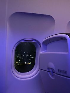 an airplane window with the city lights seen through it