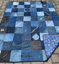 a blanket made out of old jeans is laying on the ground