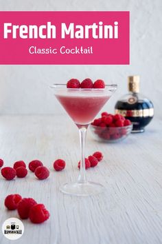 raspberry martini in a coupe glass with berries scattered around