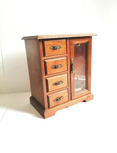 a small wooden cabinet with drawers on top