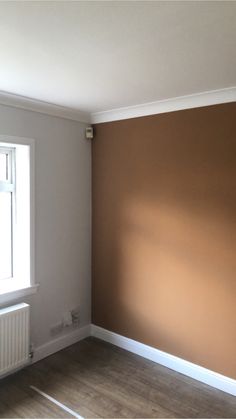 an empty room with brown walls and white trim on the wall is pictured in this image