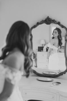 a woman is looking at herself in the mirror