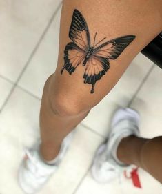 a woman's leg with a butterfly tattoo on it