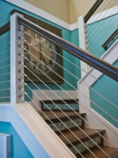 there is a clock on the wall next to some stairs and railings in this house