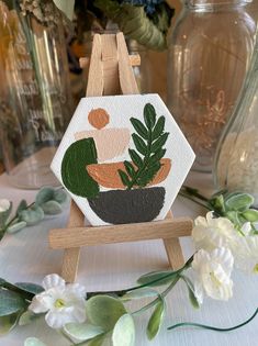 a small potted plant sitting on top of a wooden easel