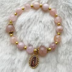 This is a handmade rosary bracelet adorned with Our Lady of Guadalupe medal. Cord used is stretchy. It includes 10 + 3 Hail Mary beads (8mm pink Quartz) and 2 slightly larger Our Father beads (10mm pink Quartz).   Each bracelet includes a storage pouch. Length: approximately 7-7.5 inches (small to medium adult wrist) Part of the earnings made from these rosaries will go towards funds for the discernment of our little ones' vocation. Please help us pray that they may choose a good and Holy one in Handmade Rosary, Virgin Of Guadalupe, Our Lady Of Guadalupe, Rosary Bracelet, Our Father, Pretty Beads, Lady Of Guadalupe, Hail Mary, Catholic Gifts