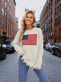 Stand out in style with our American Flag Relaxed Knit Sweater! This quirky and fun sweater features the iconic stars and stripes design, adding a playful touch to your look. Stay comfortable and show off your patriotic side with this cozy and unique sweater. Size Guide: Model is 5’7” tall, and has a 32.7” bust, 24.6”waist, & 36.2” hips. She is wearing a S / US 4 / AU 8. This sweater is true to size. Feature: Ripped crew neckline. Long sleeves. Ripped knit fabrication details. Not lined. Oversized Relaxed Fit. Material: 100% Acrylic. Care Instructions: Machine wash / Cold hand wash. Americana Long Sleeve Sweater For Fall, Long Sleeve Americana Sweater For Fall, Fall Americana Long Sleeve Sweater, Fall Flag Print Crew Neck Sweater, Fall Flag Print Long Sleeve Sweater, Long Sleeve Flag Print Sweater For Fall, Casual Crew Neck Sweater With Star Print, Fall Long Sleeve Flag Print Sweater, Knit Sweater With Star Print Long Sleeve