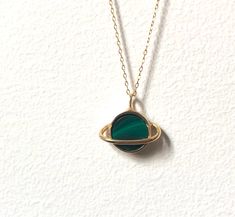 "This sweet pendant is made using a saturn setting that I handmade and had cast in brass, which is then plated in shiny 14k gold. A beautiful banded green malachite is set in the center, and it hangs on an 18\" 14k gold-filled chain. Perfect for that space loving gal. Also available with a lapis, abalone, opal/turquoise/copper mash up, moonstone, or turquoise." Tarnish Resistant Green Round Jewelry, Green Tarnish Resistant Round Jewelry, Handmade Gold Malachite Necklaces, Green Brass Jewelry As Gift, Green Brass Jewelry For Gifts, Handmade Gold Necklaces With Malachite, Green Brass Jewelry For Gift, Green Brass Jewelry Gift, Handmade Gold Necklace With Malachite