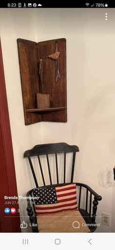 a chair with an american flag on it in front of a wooden wall hanging from the ceiling