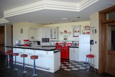 a kitchen with red and white appliances and checkered flooring on the wooden floors