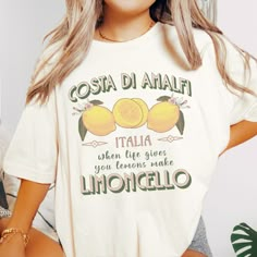 When life gives you lemons make limoncello! This cute Limoncello Costa Di Amalfi, Italy t-shirt brings sweet Italian vibes to life and has a cool, vintage poster style. This tee is super soft & comfy. Perfect for traveling around Italy, showing your love of Italy, sporting some Italian pride, or just because limoncello is so delicious.😉 Check out all our trendy apparel & gift items at https://bellawarriorboutique.etsy.com 💌Enjoy FREE SHIPPING IN THE U.S. ON ORDERS OF $35 OR MORE - *Shipping ch Casual Lemon Tops For Summer, Casual Crew Neck Top With Lemon Print, Yellow Lemon Print Crew Neck Top, Yellow Crew Neck Top With Lemon Print, White Crew Neck T-shirt With Lemon Print, White Short Sleeve T-shirt With Lemon Print, White Short Sleeve Top With Lemon Print, Yellow Lemon Print T-shirt For Spring, Spring Yellow T-shirt With Lemon Print