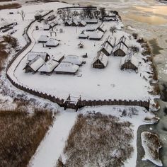 an aerial view of a small village in the middle of snow covered fields and water