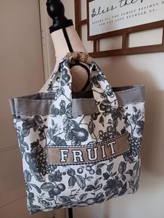 a bag is hanging up on a coat rack in front of a wall with a sign that says fruit