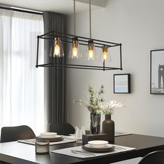 a dining room table with plates and bowls on it, hanging from a light fixture