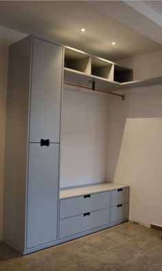 an empty room with some white cabinets and drawers in it, including the door to the closet