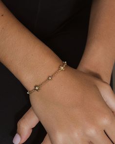 Elevate your wristwear game with the Vallie Bolo Bracelet. Adorned with lustrous pearls and delicate flower pendants, this adjustable bracelet adds a touch of elegance to any outfit. A must-have for the sophisticated and exclusive fashion connoisseur. Materials: 14K gold or rhodium plated brass, shell pearls Features: Measures 9" length, 0.35" & 0.45" charms, 1.5mm chain, 2mm & 2.5mm pearls, Lead & Nickel free, bolo/sliding knot- one size fits most Elegant Adjustable Jewelry With Flower Charm, Elegant Gold Beaded Bracelet With Flower Charm, Elegant Adjustable Flower Bracelet, Elegant Adjustable Charm Bracelet With Pearl, Elegant Adjustable Pearl Chain Charm Bracelet, Elegant Adjustable Pearl Charm Bracelet, Elegant Beaded Bracelets With Flower Charm, Elegant Adjustable Flower Pearl Bracelet, Elegant Flower-shaped Beaded Bracelets For Party