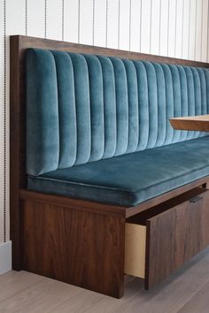 a wooden bench with blue velvet upholstered seat and storage drawers on the side