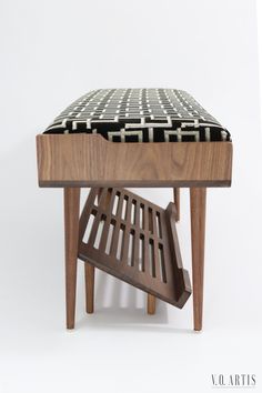 a wooden bench with a black and white checkered cushion on it's seat