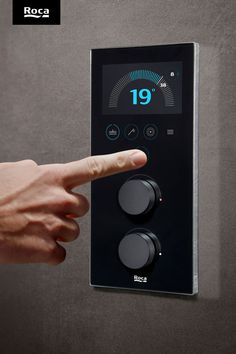 On a grey wall is a black unit. There is a screen at the top, 4 buttons below and then two large circular dials. A hand is in frame, about to press a button. Roca Bathroom, Clean Program, Smart Bathroom, Smart Solutions, Bathroom Inspo, Kit Homes, Master Bedrooms Decor, Modern Bathroom, Bathroom Design