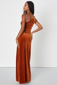 a woman in an orange dress is standing and looking off to the side with her hands on her hips