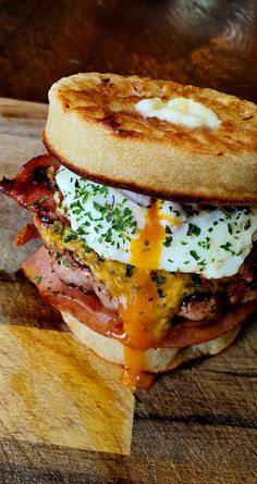 a bacon, egg and cheese sandwich sitting on top of a wooden cutting board