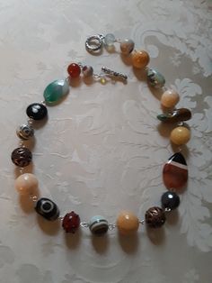 A beautiful assorted gemstone necklace chain linked. Assorted beads are sandstone, carnelian, onyx, jasper, turquoise and other assorted beads. These beautiful beads measure from.12mmm to 18mm.the flat beads measure 35mm by 24mm. A great look for any occasion. Multicolor Agate Beaded Necklaces With Oval Beads, Multicolor Beaded Agate Necklaces, Multicolor Agate Beaded Necklaces, Multicolor Carnelian Beaded Necklaces With Large Beads, Multicolor Carnelian Beaded Necklace With Large Beads, Multicolor Agate Gemstone Bead Necklaces, Multicolor Agate Large Beaded Necklaces, Multicolor Agate Necklaces With Colorful Beads, Multicolor Agate Beaded Necklace With Large Beads