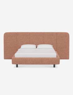 a bed that is made up with a headboard and pillows on top of it