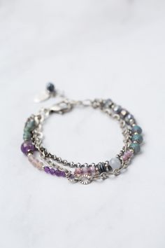 Experience the beauty and versatility of the Reflections Collection. Each piece is thoughtfully handcrafted using carefully chosen materials. This multistrand bracelet measures 7.5-8.5" and is completed an antique silver plated brass extender chain and lobster claw clasp. Elevate your style with Reflections. Antique Silver Plated Brass (lead and nickel free) Amethyst, Blue Lace Agate, Pearl 7.5-8.5", adjustable with antique silver plated brass lobster claw clasp We hand select our natural materi Adjustable Silver Beaded Fusion Bracelet, Adjustable Sterling Silver Bracelets For Layering, Adjustable Sterling Silver Beaded Fusion Bracelets, Adjustable Hand-strung Fusion Jewelry, Adjustable Multi-strand Sterling Silver Bracelet, Bohemian Silver Agate Jewelry, Adjustable Sterling Silver Bracelets With Extender, Fusion Style Metal Jewelry With Natural Stones, Handmade Metal Jewelry For Layering