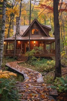 a cabin in the woods surrounded by trees and leaves with fall foliage on the ground