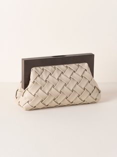 Carry your essentials in style with Shiraleah's Charlotte Frame Clutch. This handhel purse features a vegan leather woven texture and a wood top handle, adding a sophisticated edge to this chic silhouette. Measuring L 11" × W 4" × H 7.25", and equipped with a magnetic frame closure and inner slip pocket, the Charlotte Frame Clutch is the perfect addition to your favorite outfit. Pair with other items from Shiraleah to complete your look! Color: Ivory L 11" × W 4" × H 7.25" Woven Pu And Wood Magn Chic Woven Leather Clutch For Everyday Use, Chic Everyday Woven Leather Clutch, Chic Textured Leather Rectangular Clutch, Chic Rectangular Textured Leather Clutch, Chic Clutch With Braided Handles For Everyday, Chic Everyday Clutch With Braided Handles, Chic Rectangular Intrecciato Clutch, Chic Brown Woven Clutch, Chic Natural Clutch With Braided Handles