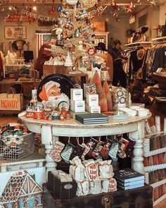 a christmas tree in a store filled with lots of holiday decorations and gifts for sale