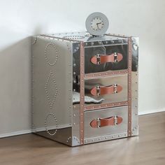 a metal chest with three drawers and a clock on top