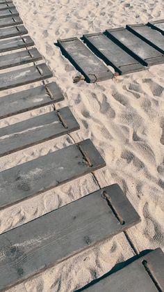 an empty beach with wooden steps leading up to the water and sandy area that is covered in sand