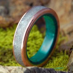 a wedding ring that is sitting on some moss