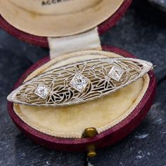 This vintage navette shaped filigree brooch is accented with two (2) bead set old European cut diamonds, and one (1) bead set round brilliant cut diamond. The brooch measures 45.1mm by 12.5mm and is crafted in 14k white gold. Yellow Gold Filigree Brooches For Wedding, Antique Wedding Brooch With Intricate Design, Ornate Yellow Gold Wedding Brooch, Wedding Yellow Gold Filigree Brooches, Formal Diamond Brooch With Intricate Design, Formal Diamond Brooches With Intricate Design, Classic Wedding Brooches With Intricate Design, Art Deco Wedding Brooches With Diamond Accents, Victorian Wedding Brooches With Intricate Design