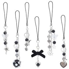 six different styles of charms hanging from black cord with white and black beads on them