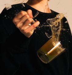 a person holding a wine glass with some liquid pouring out of it and splashing on them