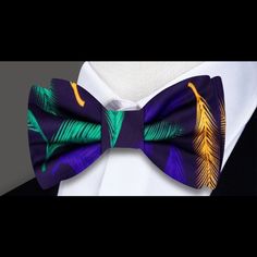 Unveiling Elegance: The Black Silk Bow Tie with Green, Purple, and Yellow Feather Pattern Step into a world of sophistication and allure with our Black Silk Bow Tie adorned in a striking symphony of Green, Purple, and Yellow Feathers. This bow tie stands as an embodiment of refined style and vibrant charisma, offering a distinct touch to your ensemble. A Symphony of Color: Exploring the Design Crafted from opulent silk, this bow tie hosts a mesmerizing tapestry of vivid hues. The intricate Green Elegant Black Summer Ties, Elegant Fitted Multicolor Bow Tie, Deep Purple Dress, Types Of Bows, Purple Dress Shirt, Classic White Dress, Yellow Feathers, Tie Pattern, Silk Bow Ties