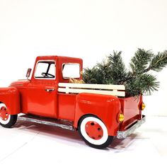 an old red truck with a christmas tree in it's flat bed, on a white background