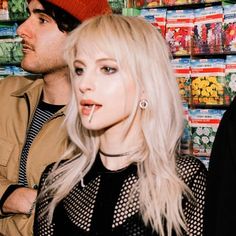 two people standing next to each other in front of stacks of candy