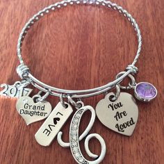 "Granddaughter Bracelet Our granddaughter bracelet makes the perfect gifts, for any granddaughter from her grandmother. It features a 7-8\" stainless steel adjustable bracelet, a 2017 charm, granddaughter charm, love charm, personalized initial charm, you are loved charm and a round Crystal birthstone or favorite color charm. Each it will be attractively packaged in a sheer organza bag and a gift box for gift giving. Thanks for visiting our site." Mother's Day Birthstone Charm Bracelet For Anniversary, Mother's Day Anniversary Charm Bracelet With Birthstone, Mother's Day Anniversary Birthstone Charm Bracelet, Charm Bracelet For Birthday And Valentine's Day, Round Charm Bracelet For Birthday And Valentine's Day, Personalized Name Bracelet For Valentine's Day Birthday, Mother's Day Birthstone Name Bracelet For Birthday Gift, Mother's Day Birthday Gift Name Bracelet With Birthstone, Personalized Name Bracelet For Birthday On Valentine's Day