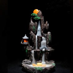 a small waterfall made out of rocks with an orange on top