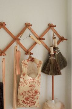 there are some brooms and other items hanging on the wall next to each other