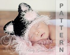 a baby wearing a black and white hat laying on top of a pink fluffy blanket