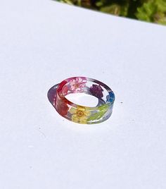 This pride ring has been decorated with different flowers with different colours. If you wish to change the pride colours to another flag, please message me. Rainbow Flower-shaped Jewelry For Gifts, Colorful Handmade Rings For Gifts, Colorful Handmade Rings As Gift, Colorful Handmade Ring Gift, Unique Rainbow Colored Rings As Gift, Unique Rainbow Rings As Gift, Unique Rainbow Rings For Gifts, Multicolor Flower Shaped Jewelry With Pressed Flowers, Multicolor Flower Jewelry With Pressed Flowers