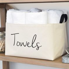 a white towel bag with the word towels on it sitting on top of a shelf